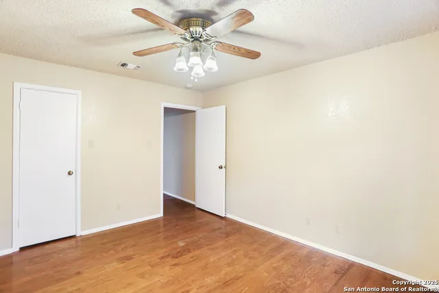 a view of an empty room with wooden floor