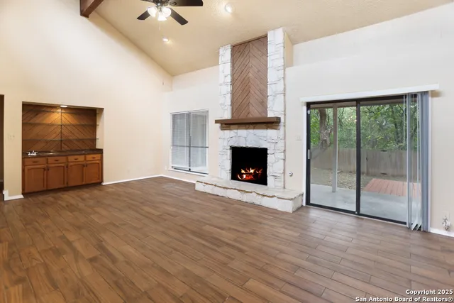 a view of empty room with wooden floor and fireplace