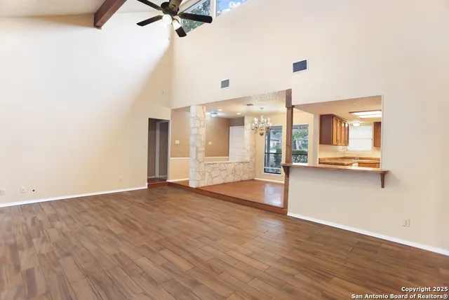 a view of a kitchen with wooden floor and a ceiling fan
