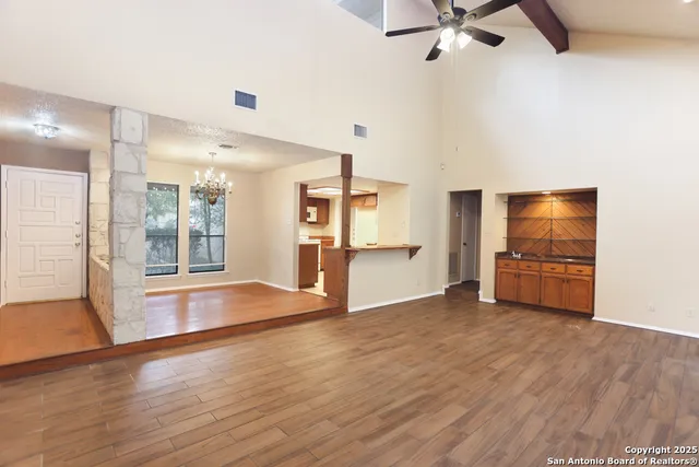 a view of an empty room with a window and wooden floor