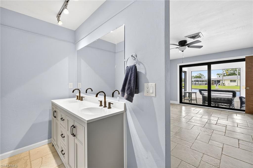 18071 Traverse Drive Alva, FL 33920 - Photo 16 of 50 a bathroom with a double vanity sink a mirror and bathtub