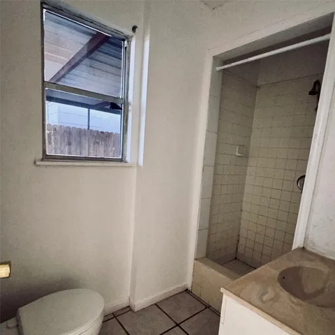 a bathroom with a granite countertop toilet and a sink