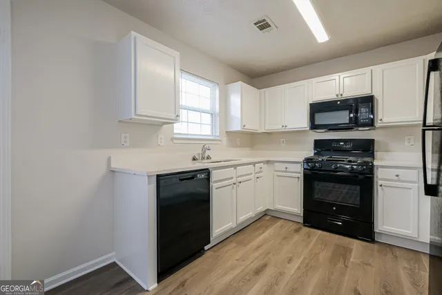a kitchen with granite countertop a refrigerator and a stove top oven