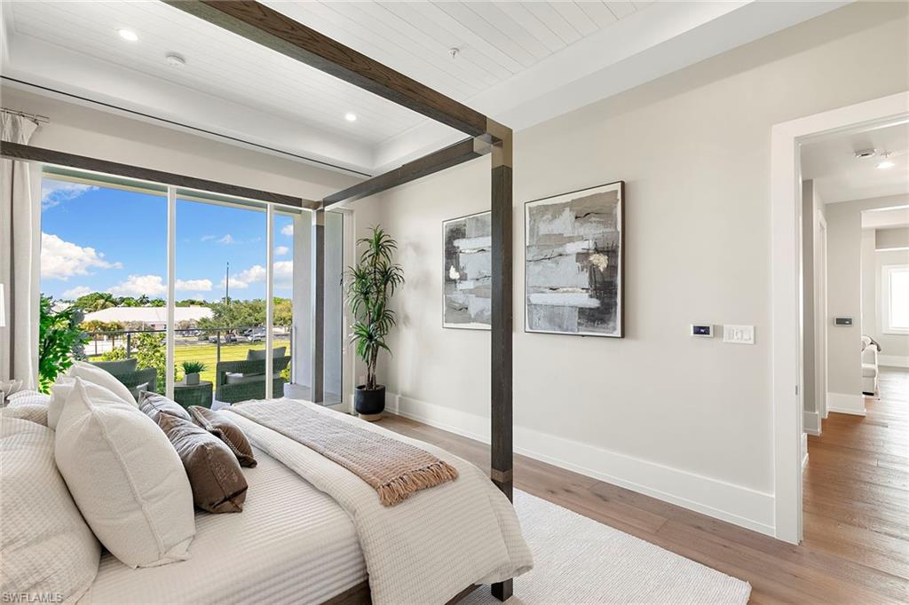 201 8th Street South, Unit 301 Naples, FL 34102 - Photo 19 of 43 a bedroom with a large bed and a large window