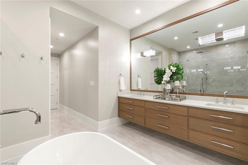 201 8th Street South, Unit 301 Naples, FL 34102 - Photo 22 of 43 a bathroom with a granite countertop sink a large mirror and shower