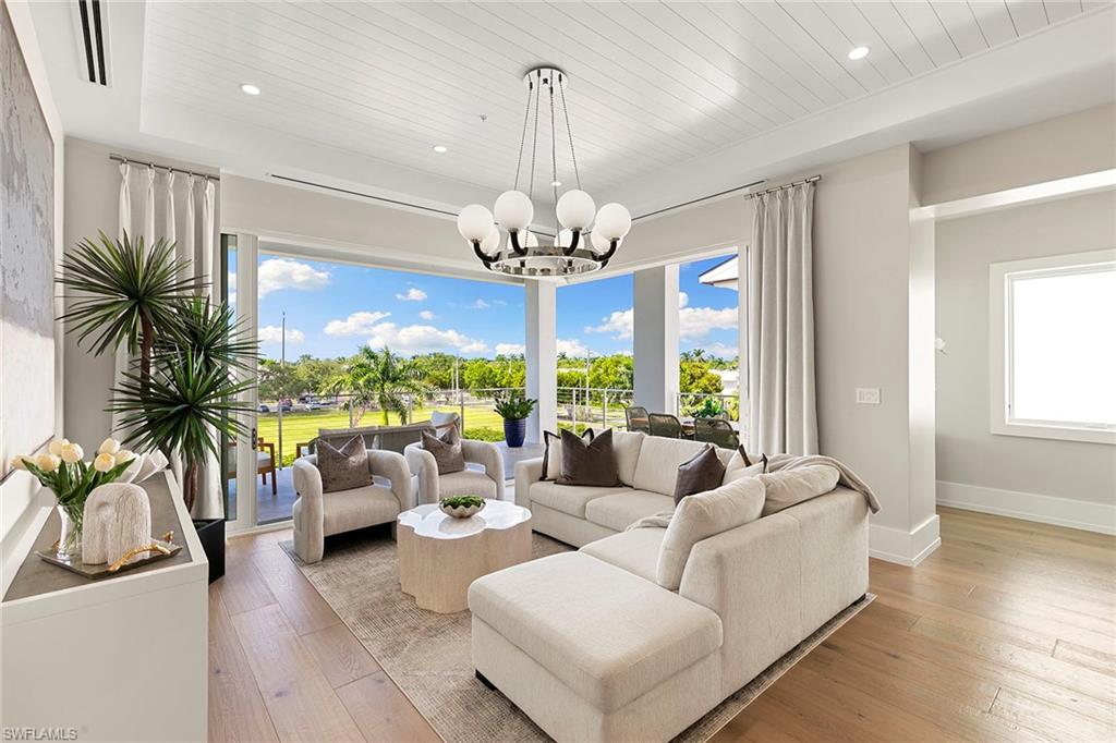 201 8th Street South, Unit 301 Naples, FL 34102 - Photo 3 of 43 a living room with patio furniture and a chandelier