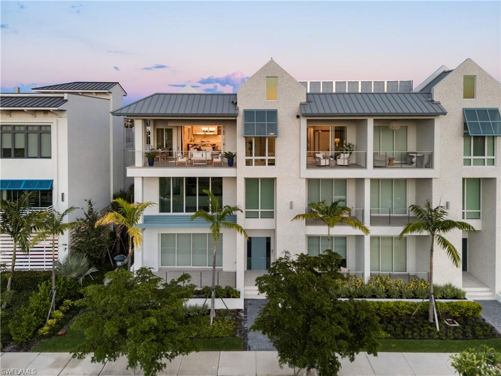 201 8th Street South, Unit 301 Naples, FL 34102 - Photo 40 of 43 a front view of a residential apartment building with a yard