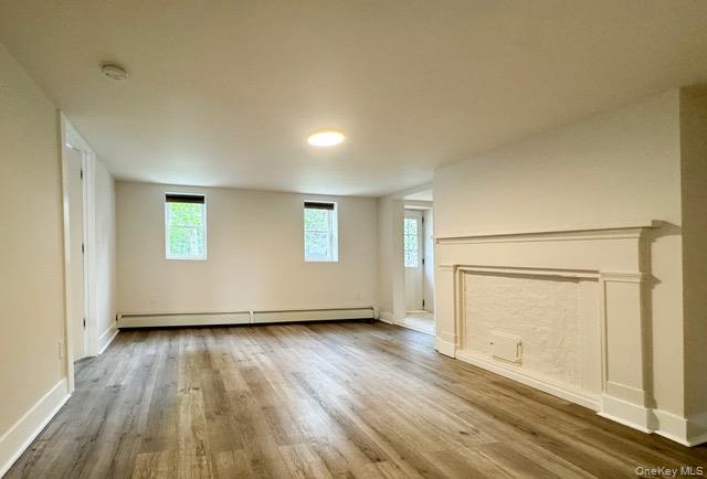12 Grove Street, Unit C Beacon, NY 12508 - Photo 13 of 13 Unfurnished living room with wood finished floors and a baseboard heating unit