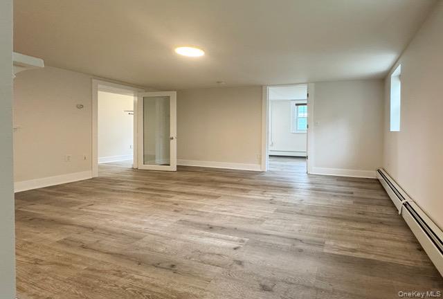 12 Grove Street, Unit C Beacon, NY 12508 - Photo 2 of 13 Unfurnished room featuring a baseboard heating unit and light wood-style floors