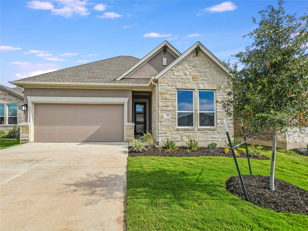 a front view of a house with a yard and garage