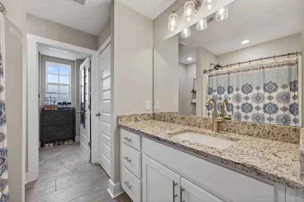 a bathroom with a granite countertop sink and a toilet