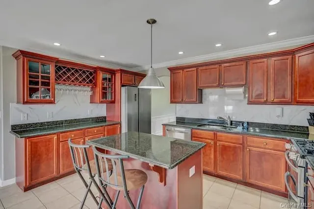 a kitchen with stainless steel appliances granite countertop a sink a stove and refrigerator