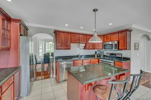 a kitchen with stainless steel appliances granite countertop a stove top oven a sink dishwasher and cabinets with wooden floor