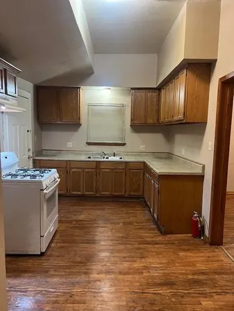 a large kitchen with wooden floors and stainless steel appliances
