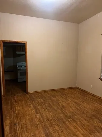 a view of an empty room and kitchen