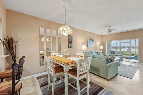 a living room with furniture a chandelier and a dining table