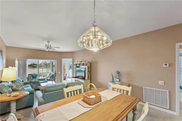 a view of a dining room with furniture a chandelier and wooden floor