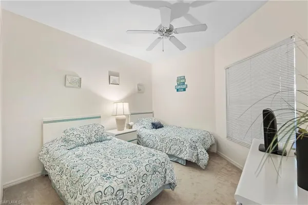 a bedroom with two beds and painting on the wall