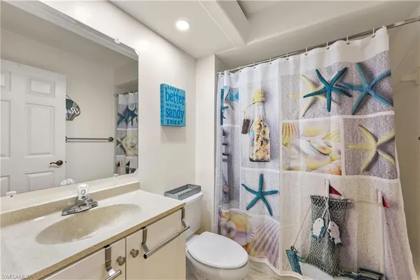 a bathroom with a sink vanity mirror and toilet
