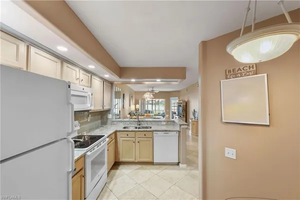 a kitchen with a sink cabinets stainless steel appliances and a window