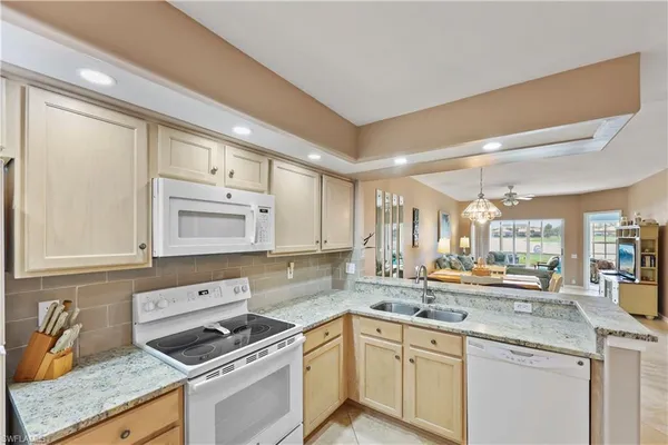 a kitchen with stainless steel appliances granite countertop a sink stove and cabinets