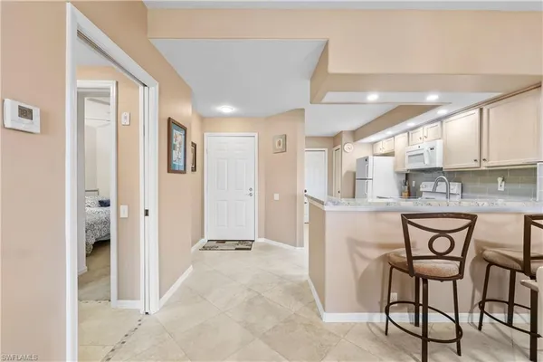 a kitchen with a refrigerator and table chair