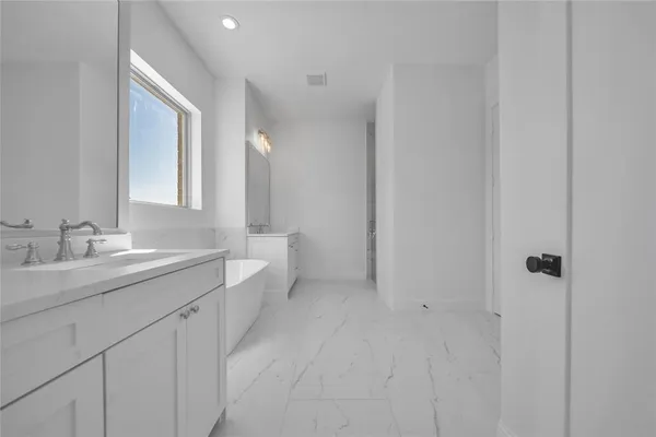 a spacious bathroom with a double vanity sink a toilet and a mirror