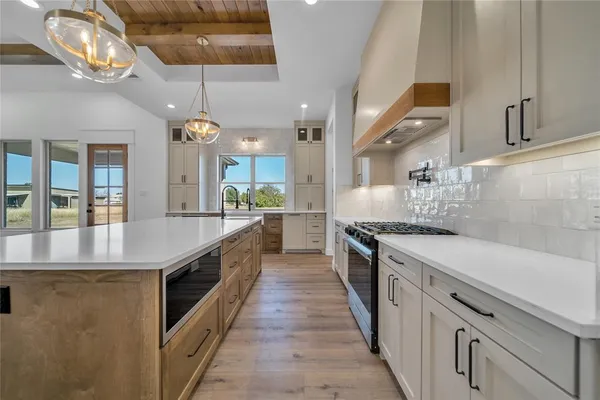 a large kitchen with stainless steel appliances kitchen island a large counter space a sink and cabinets