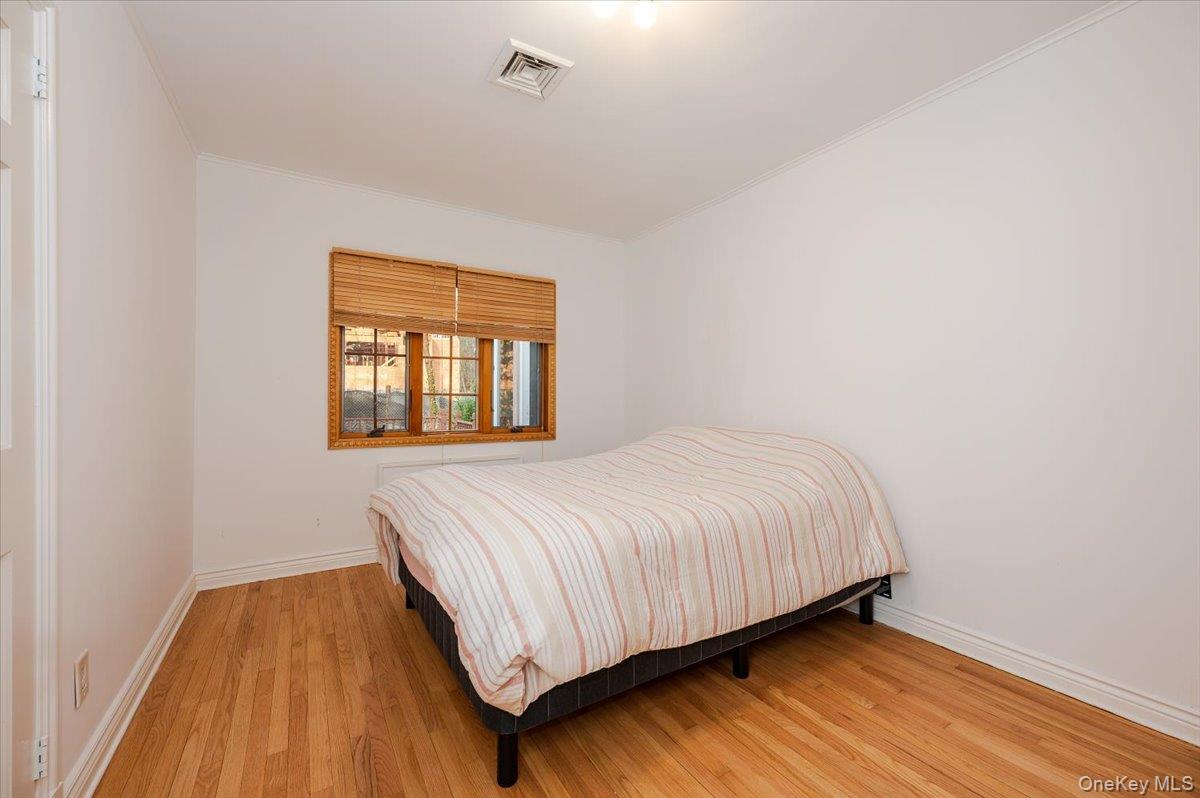 18 Locust Drive Great Neck, NY 11021 - Photo 17 of 29 a bed sitting in a bedroom next to a window