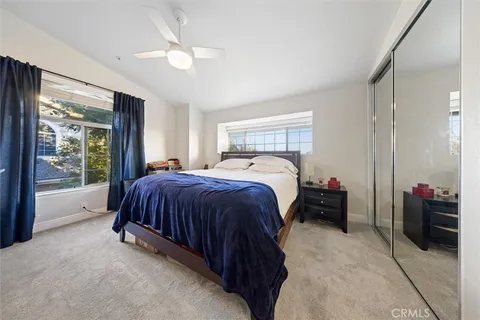 a spacious bedroom with a bed and a large window