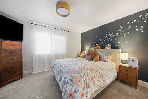 a bedroom with a bed and flat screen tv