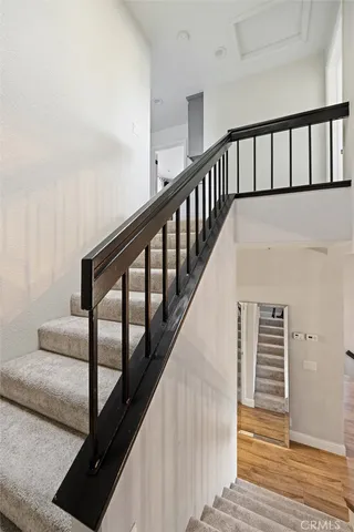 a view of staircase with lots of frames on wall and wooden floor