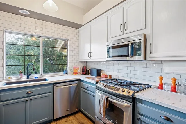 a kitchen with stainless steel appliances a sink a stove and cabinets