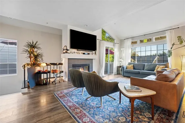 a living room with furniture a flat screen tv and a fireplace