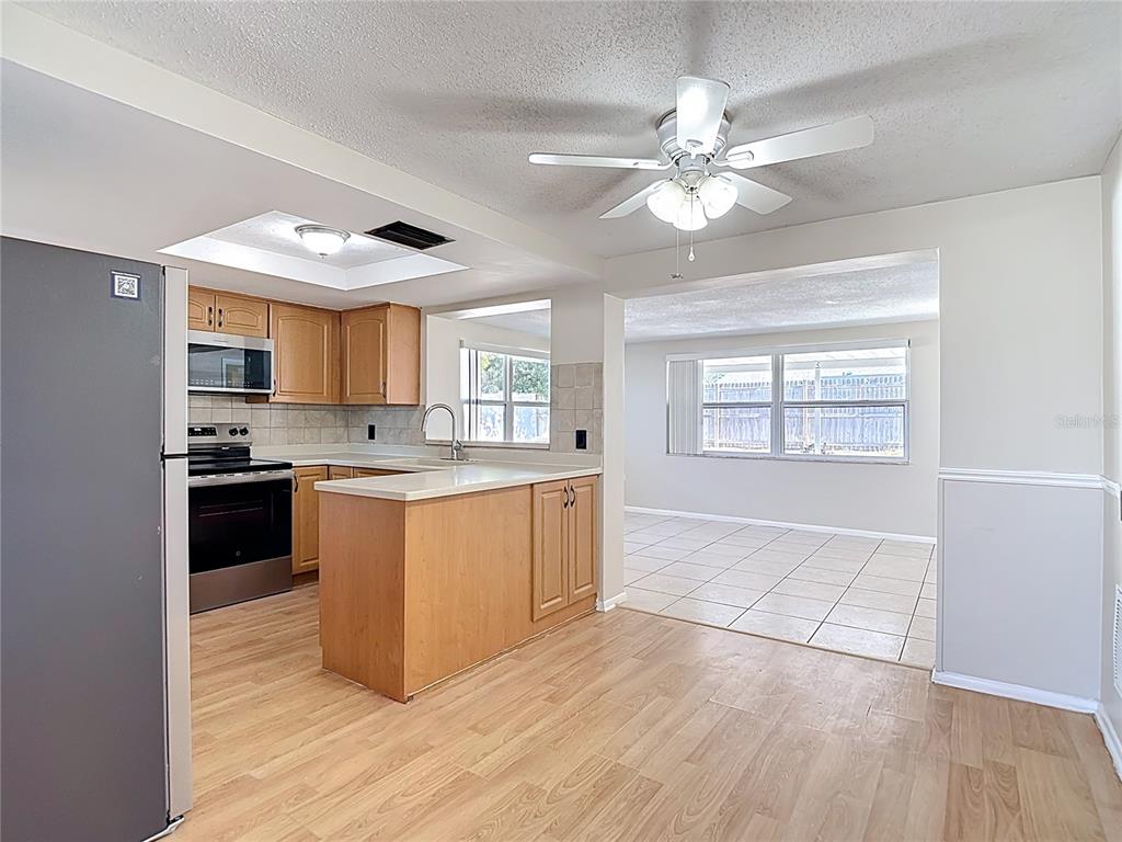 10806 Jason Road Port Richey, FL 34668 - Photo 11 of 46 a large kitchen with kitchen island granite countertop a stove top oven a sink a counter space and cabinets