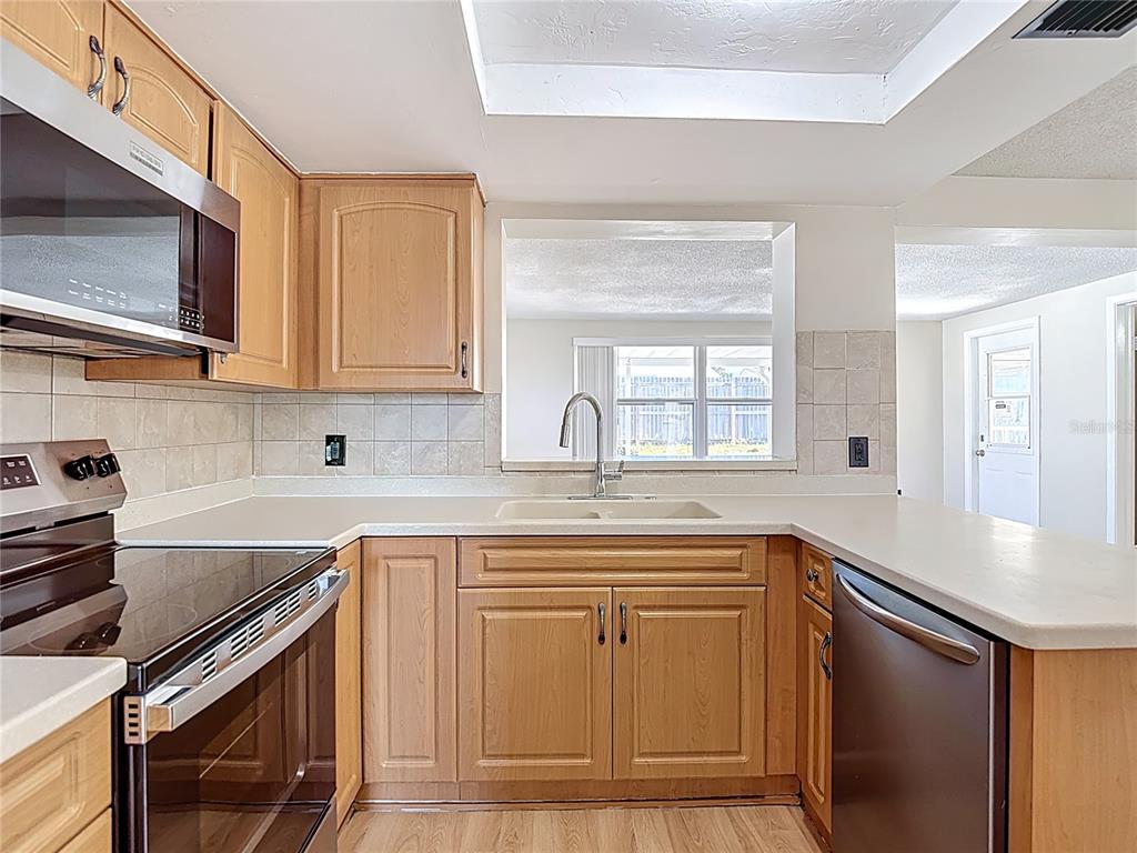 10806 Jason Road Port Richey, FL 34668 - Photo 14 of 46 a kitchen with granite countertop a sink stove and cabinets