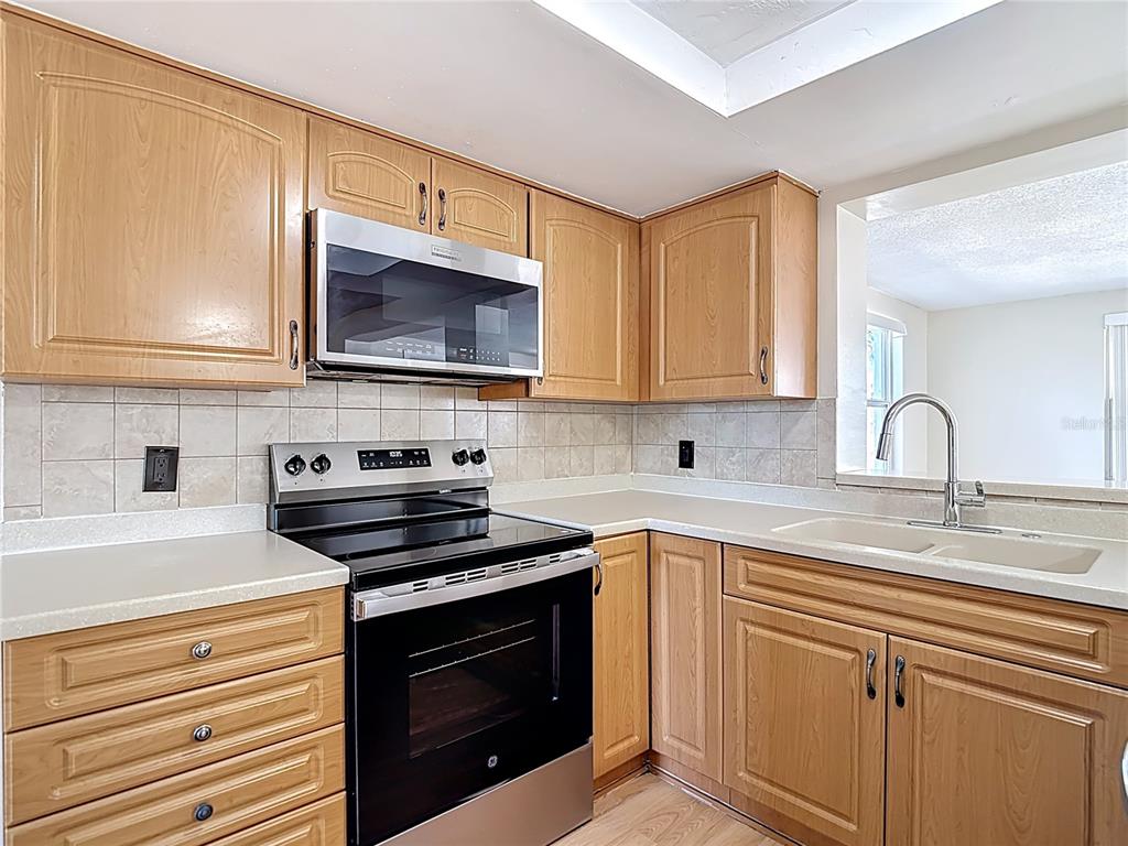10806 Jason Road Port Richey, FL 34668 - Photo 15 of 46 a kitchen with granite countertop cabinets stainless steel appliances and a sink