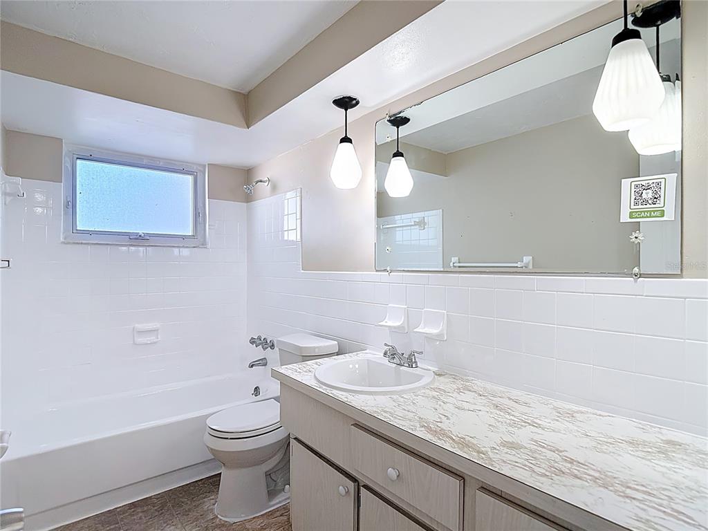 10806 Jason Road Port Richey, FL 34668 - Photo 25 of 46 a bathroom with a granite countertop sink a toilet and bathtub