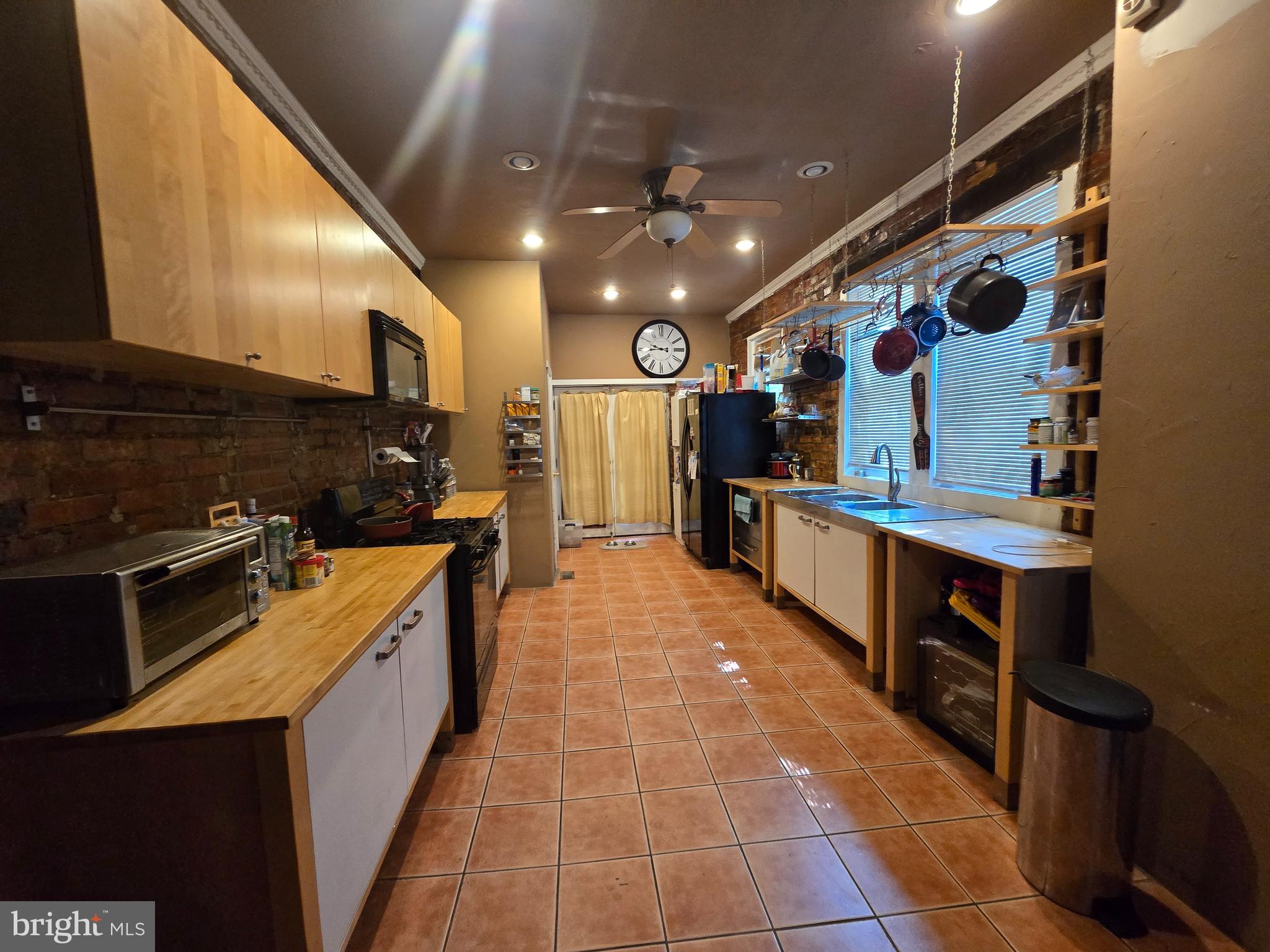 1211 North 60th Street Philadelphia, PA 19151 - Photo 10 of 14 a large kitchen with stainless steel appliances wooden cabinets and a stove top oven