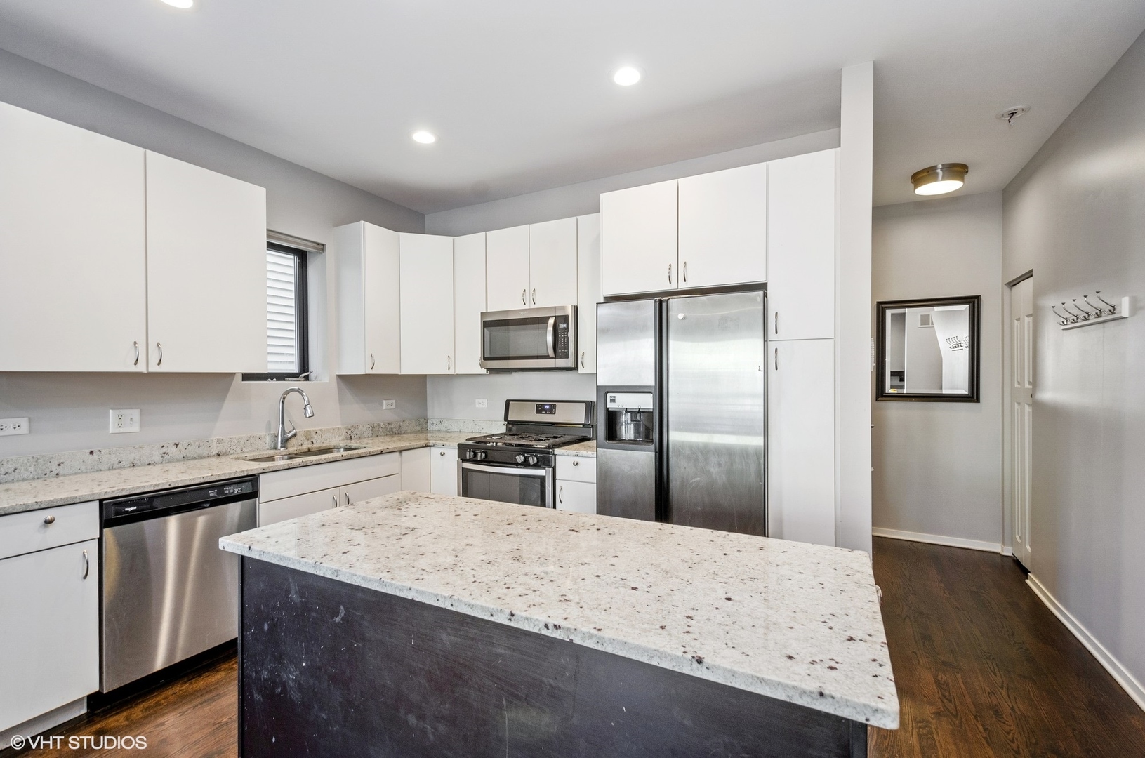 1442 North Mohawk Street, Unit 1 Chicago, IL 60610 - Photo 8 of 15 a kitchen with granite countertop a refrigerator a sink a stove and white cabinets with wooden floor