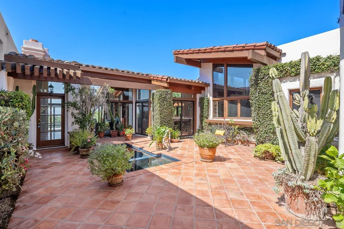 13622 Orchard Gate Road Poway, CA 92064 - Photo 5 of 40 a view of a patio with table and chairs potted plants and floor to ceiling window