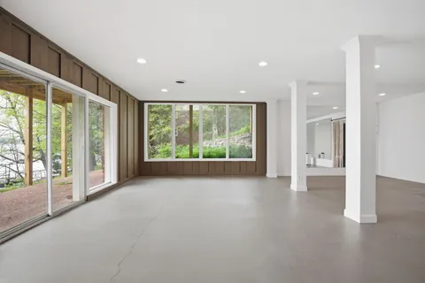 a view of a hallway with wooden floors and living room