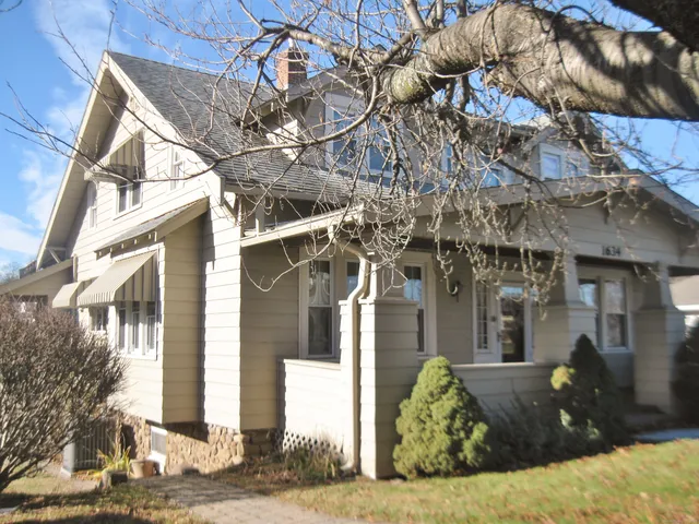 a view of a brick house with a large tree