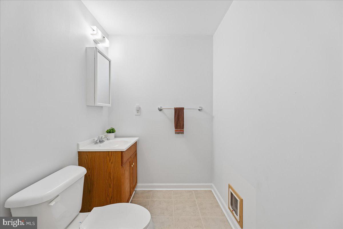 5211 Spring Branch Boulevard Dumfries, VA 22025 - Photo 20 of 32 a white toilet sitting next to a bathroom sink and vanity