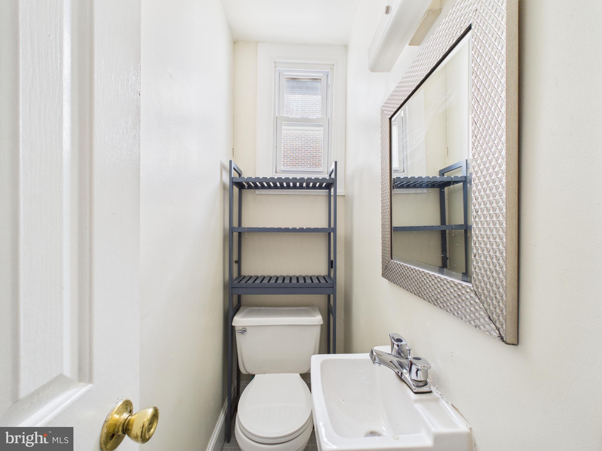3829 Hamilton Street, Unit C Philadelphia, PA 19104 - Photo 6 of 17 a bathroom with a toilet sink vanity and mirror