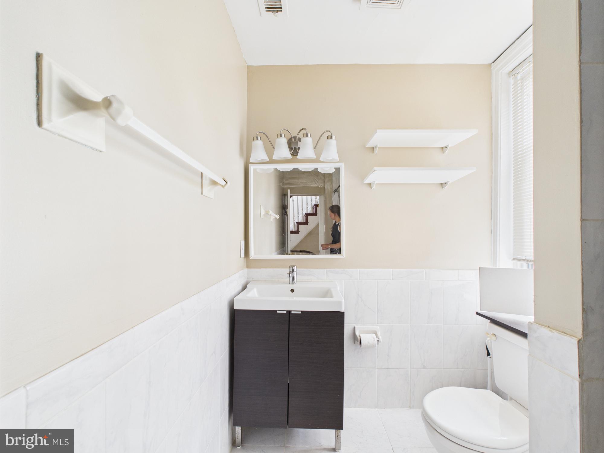 3829 Hamilton Street, Unit C Philadelphia, PA 19104 - Photo 7 of 17 a bathroom with a sink vanity mirror and toilet