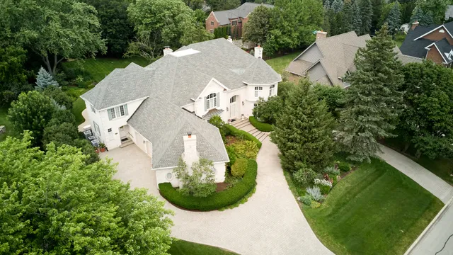 an aerial view of a house with a yard and trees