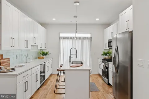a kitchen with white cabinets and sink