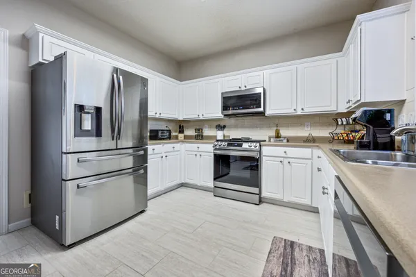 a kitchen with cabinets stainless steel appliances and a window