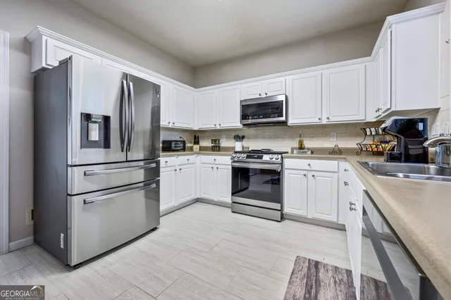 a kitchen with cabinets stainless steel appliances and a window